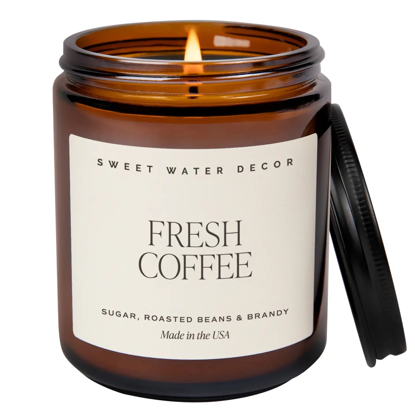 Candle in an amber jar labeled 'Fresh Coffee' by Sweet Water Decor on a white background.