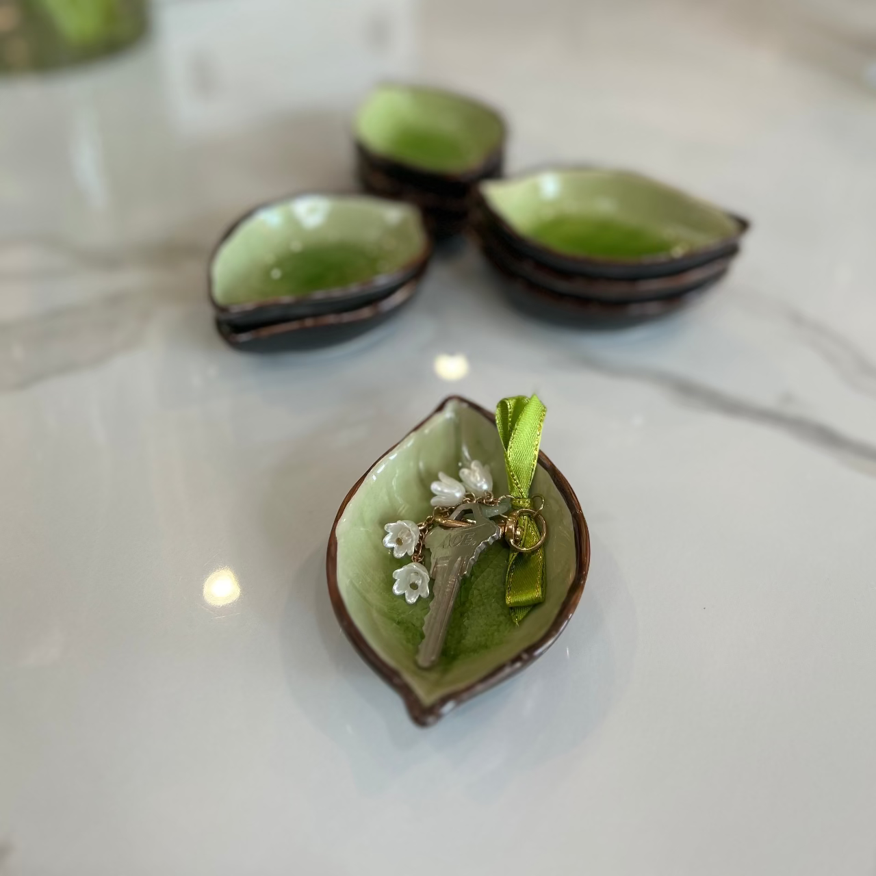 Green leaf-shaped jewelry box with decorative elements on a white surface
