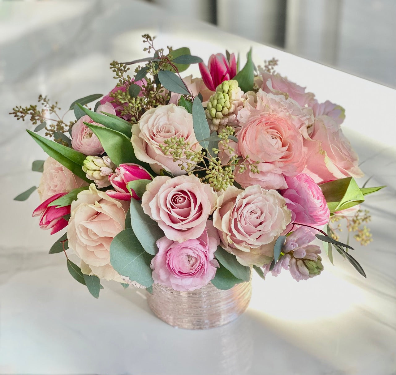pink roses convey thoughtfulness and can express just the right emotion, without saying a word. We've captured that sweet love in this enchanting array of pink blooms, including pink hyacinth, specialty ranunculus, 'Pink Mondial' roses and pink tulips. Soft green touches of eucalyptus frame the design.