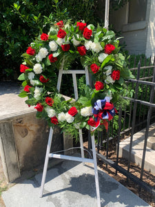 Patriotic wreath of red roses and white carnations finished with red, white and blue ribbon