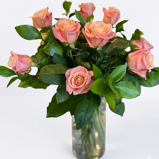 Bouquet of pink roses in a clear vase on a white background