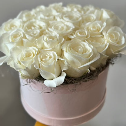 A pave design of white roses in a pink hat box.