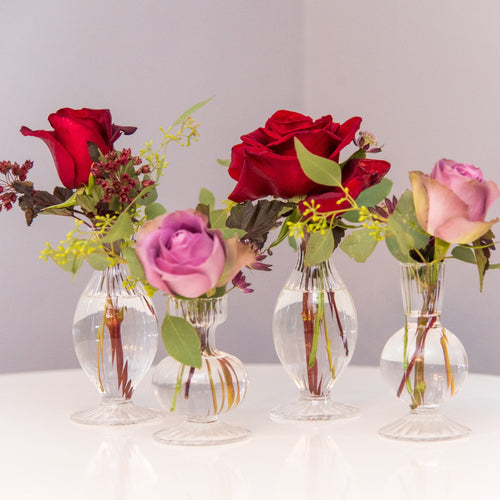 Four bud vases with seasonal blooms