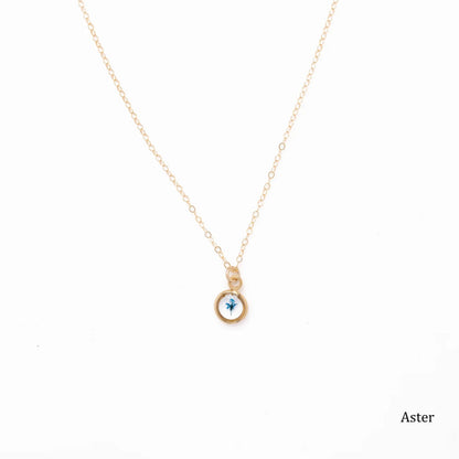 Gold necklace with a blue aster flower in the pendant on a white background