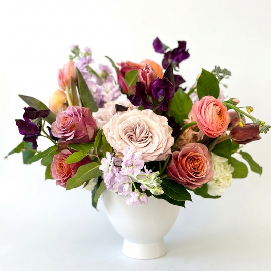 Arrangment of flowers in a white vase on a white background