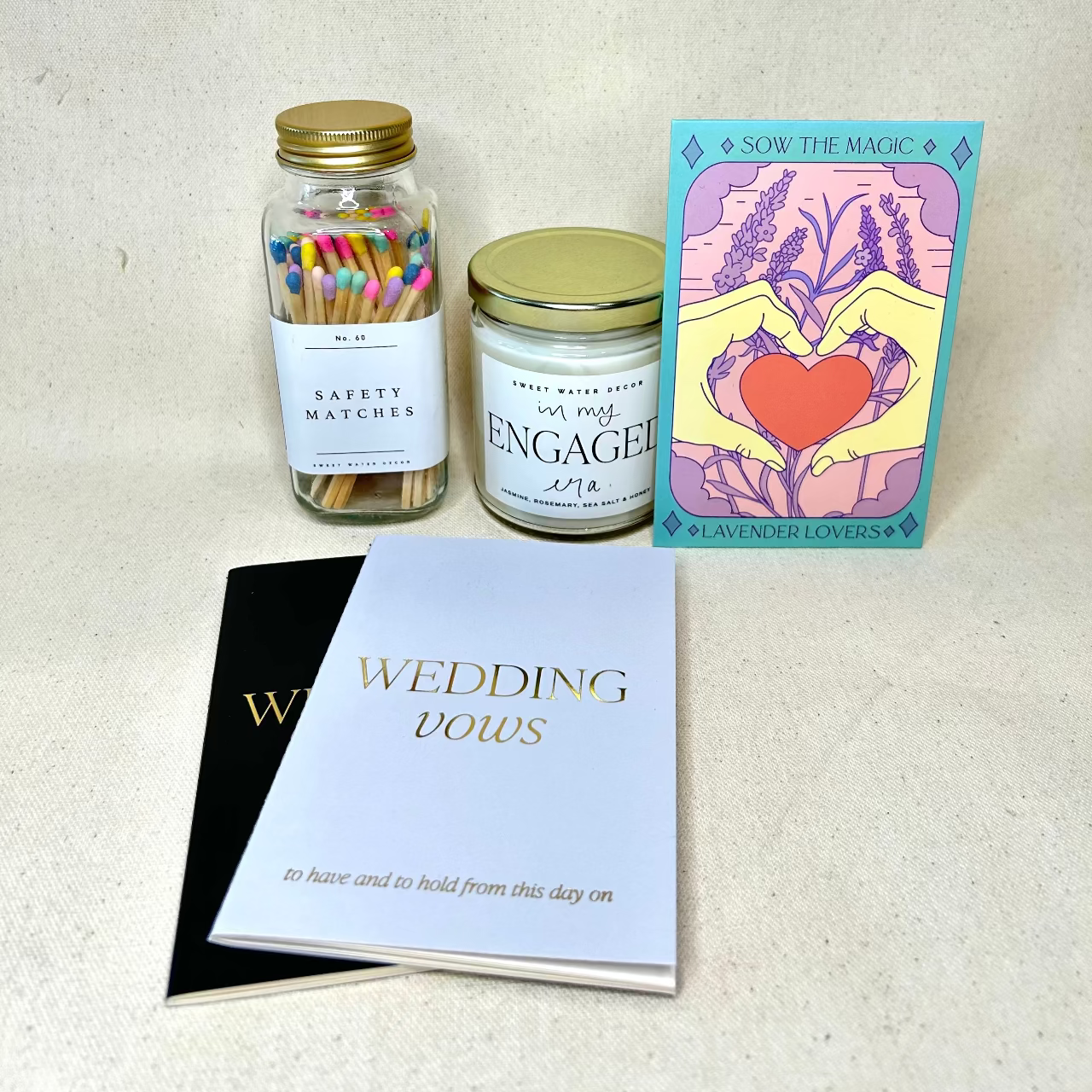Set of items including safety matches, an engaged candle, a card with wedding vows, and a card with a heart design on a white background.