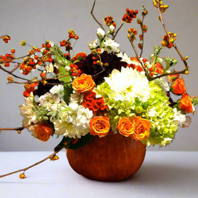Flowers in orange pumpkin centerpiece