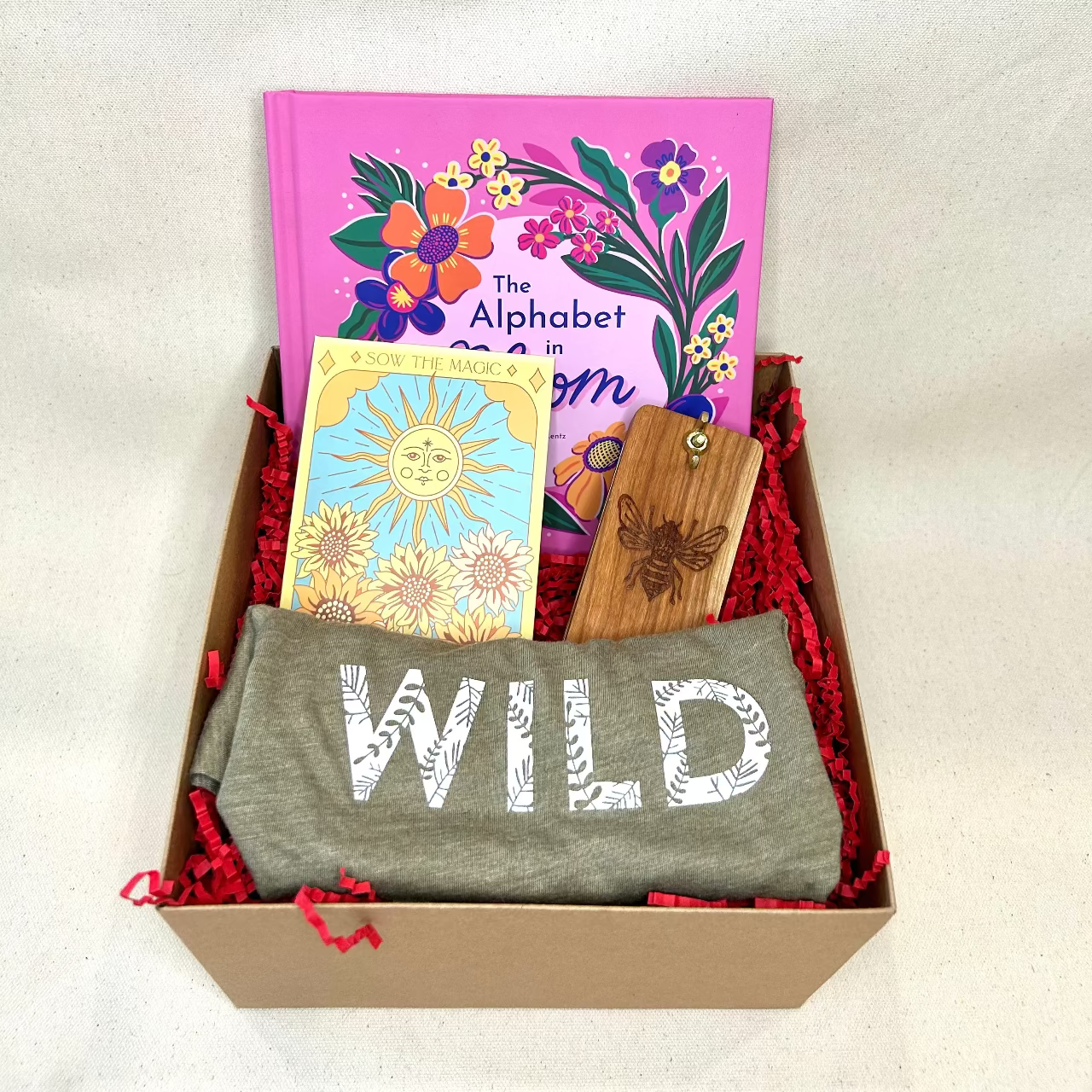 Gift box with t-shirt, book, and cards on a white background