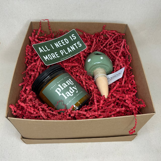 Gift box with plant care items including a jar labeled 'Plant Lady' and a small bottle on a white background.