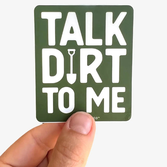 Sticker with 'Talk Dirt to Me' text held by a hand on a white background
