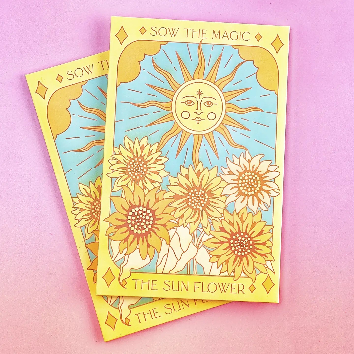 A set of brightly colored envelopes with a tarot card design featuring the sun and a flower, titled 'The Sunflower'. The envelopes are adorned with images of sunflowers and a crescent moon.