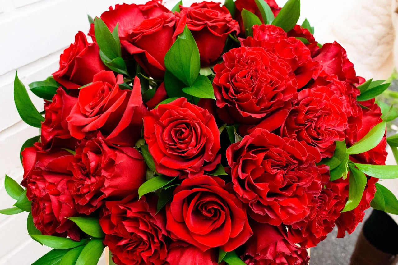 This irresistible design featured three dozen premium roses, including ruffled 'Hearts' roses and silky 'Paris roses, dressed with touches of ruscus foliage in an impressive, large bubble bowl.