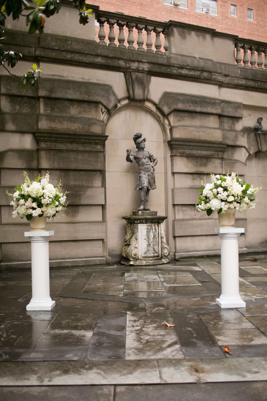 Altar arrangements for DC wedding in classic whites using hydrangea, stock, and roses in urns.