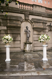 Altar arrangements for DC wedding in classic whites using hydrangea, stock, and roses in urns.